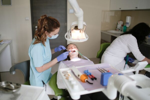 Dentist tratând o pacientă în cabinetul stomatologic modern